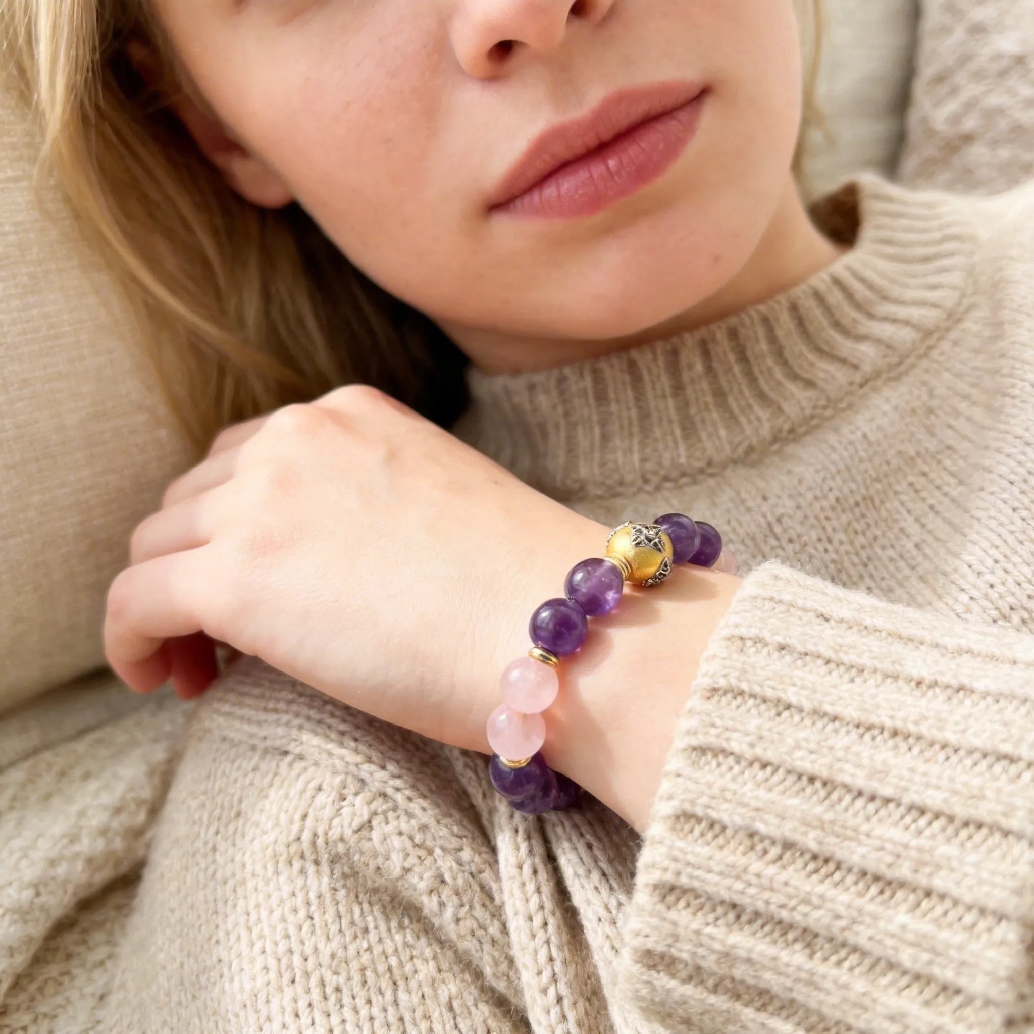 A lady wearing a bracelet with Amethysts and Rose quartz beads.